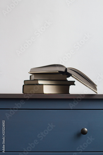 Stack Of Books On Blue Chest Of Drawers Buy This Stock Photo And