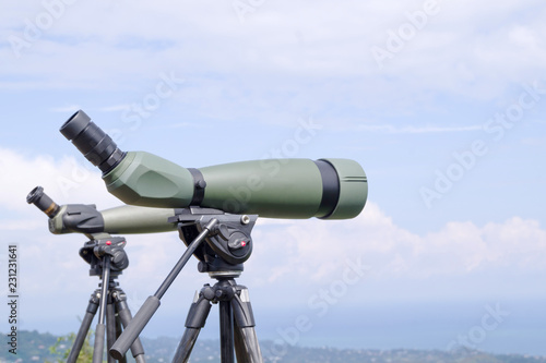 Fotografía Green spotting scope or monocular at mountain top against the background of a mountain landscape in summer day