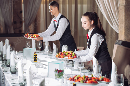 Fotografía Waiters serving table in the restaurant preparing to receive guests