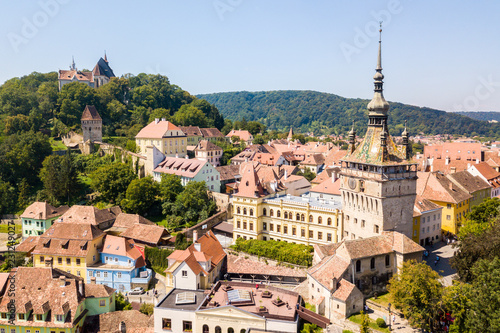 Fotografie, Obraz Green hills, spires and red tiled roofs of Walled old town of Sighisoara (Sighishoara), Mures, Transylvania, Romania