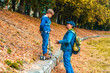 © alonaphoto - Dad with son in jeans clothes are walking along the autumnal embankment with a scooter. Father talking to son
