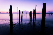 Long Exposure Image Of Dramatic Sky Seascape With Old Wooden Pole In The Sea Sunset Or Sunrise Scenery Background.
