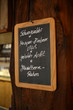 © Björn - chalkboard sign with writing in german nailed to wooden pillar
