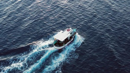 Wall Mural - Video from above, aerial view of a beautiful fishing boat that sails in the Mediterranean sea. Sardinia, Italy.