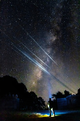 Wall Mural - silhouette of man lighting up badwater basin at night under the milky way galaxy