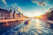 Dramatic sunset over river Seine in Paris, France, with Conciergerie and Pont Neuf. Colourful travel background. Romantic cityscape.