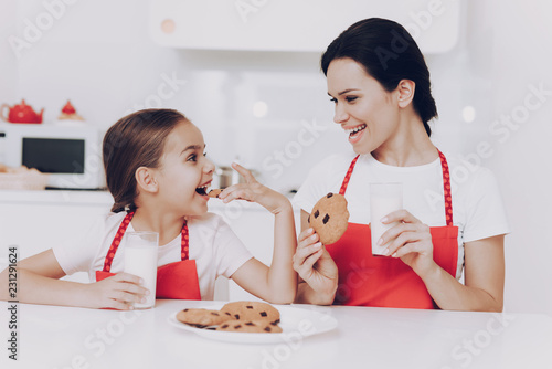 Foto  Young Girl Trying Biscuit with Mother. Mom Trying.