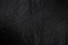 An abstract black slate background, a dark texture with a place for text