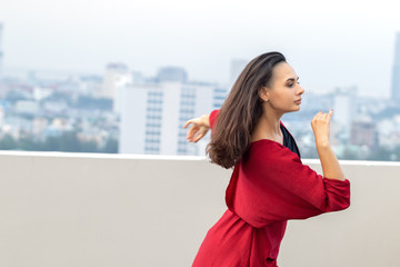 Wall Mural - Outdoor portrait of young beautiful woman dancing on the rooftop