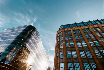 Modern offices and old middle of XX century buildings neighborhood with blue sky background.