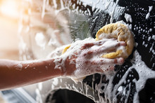 People Cleaning Car With Sponge At Car Wash