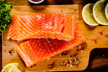 Fresh raw salmon fish served on cutting board on wooden table