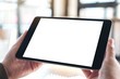 © Farknot Architect - Mockup image of hands holding and using black tablet pc with blank white desktop screen