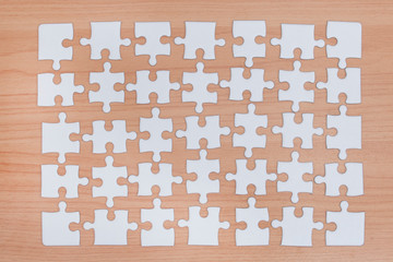 White jigsaw puzzle on wood background