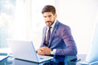 © gzorgz - Young business person sitting behind notebook in the office