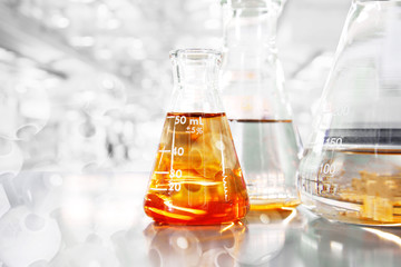 Wall Mural - orange so in conical three flasks with chemical structure in science education laboratory