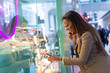 © michael spring - Young woman looking in a cake shop window