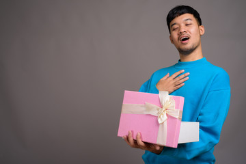 Wall Mural - Portrait of young Asian man holding gift box
