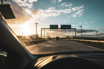 Car interior when driving on a highway in the sunset