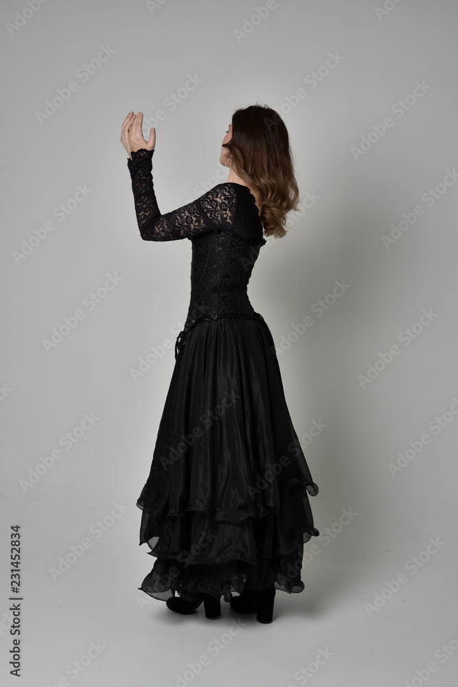 full length portrait of brunette girl wearing long black lace gown with ...