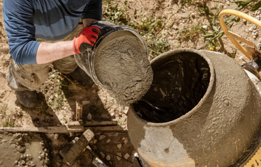 Workers pour concrete solution at a construction site