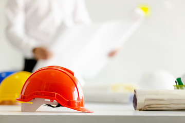 Safety helmet on table in office , engineer concept Teamwork of building construction