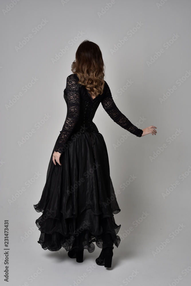 full length portrait of brunette girl wearing long black lace gown with ...