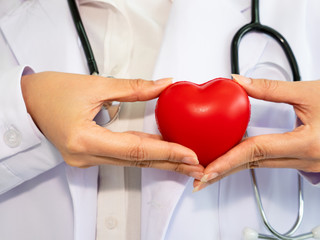 doctor hold the heart in hand. you can use for helth check heart disease.