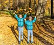 © Irina Rogova - Twin boys in the park under falling maple leaves. Autumn.