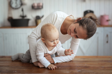 mom plays with baby in real interior communication