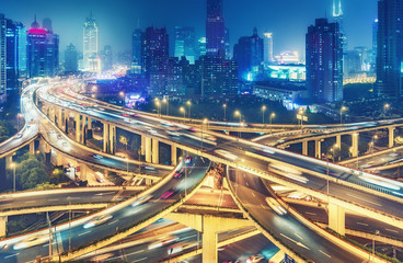 Scenic view on famous highway interchange in Shanghai, China at night. Multicolored nighttime skyline.