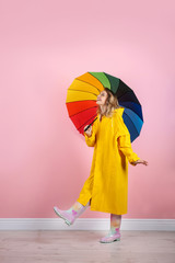 Wall Mural - Woman with rainbow umbrella near color wall