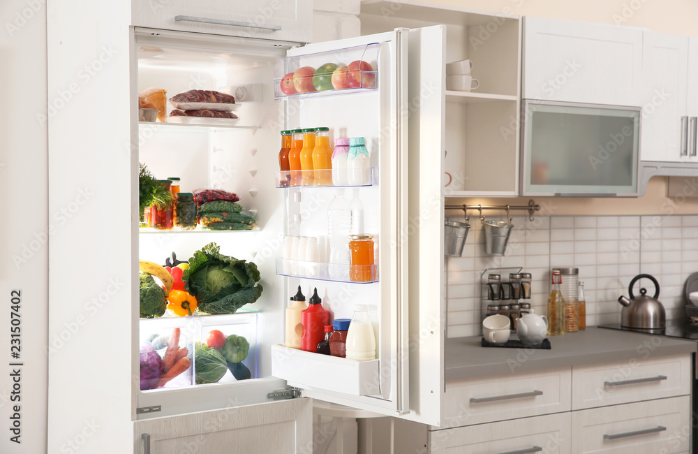Stylish kitchen interior with refrigerator full of products