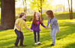 © Evgeniy Kalinovskiy - a group of small children smiling holding hands on a background of grass, a tree and a park. Children's Day, June 1, friendship, childhood.
