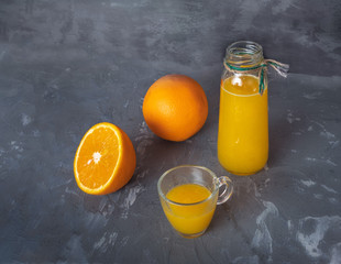 Freshly squeezed orange juice in a glass bottle, mug, sleeping orange