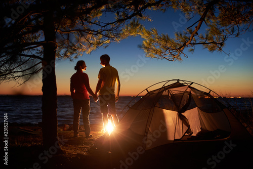 Night Camping At Lake Silhouettes Of Tourist Couple Boy And Girl Standing At Campfire Holding Hands And Looking At Each Other Near Tent Tourism Happy Relations And Active Lifestyle Concept Stock Photo Night Camping At Lake Silhouettes Of Tourist Couple Boy And Girl Standing At Campfire Holding Hands And Looking At Each Other Near Tent Tourism Happy Relations And Active Lifestyle Concept Stock Photo