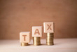 © bablab - Tax increase illustrated with wooden cubes and coins