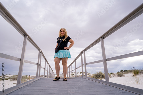 Fotografie, Obraz Adorable blonde woman photographer stands on the boardwalks of White Sands Natio