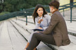 © Goran - Two young business colleagues sitting on staircase and discussing.
