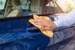 The hand of man wipes a car a yellow rag. Сar cleaning