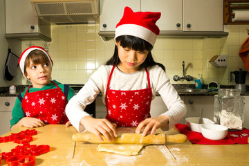 happy kids making cookies in christmas bakery  in home  kitchen