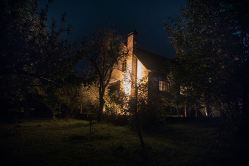 Wall Mural - Mountain night landscape of building at forest at night with moon or vintage country house at night with clouds and stars. Summer night.
