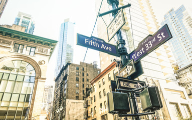 Street sign of Fifth Ave and West 33rd St in New York City - Urban concept and road direction in Manhattan downtown - American world famous capital destination on azure desaturated afternoon filter