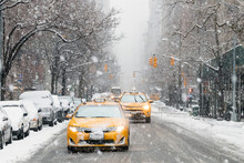 Taxis Drive Down A Snow Covered 5th Avenue During A Winter Nor'easter Storm In New York City