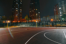 Illuminated Basketball Playground With Red Pavement, Modern New Basketball Net And Lens Flares On Background. 