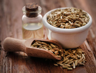 Wall Mural - Fennel seeds with essential oil in a bottle