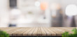 Empty brown wooden plank table top with blurred home kitchen with blur foreground leaf,Mock up template for display or montage of your design,Banner for advertise of product,panorama view,