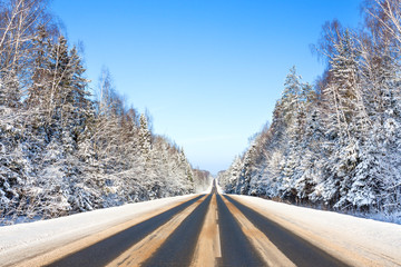 Wall Mural - winter landscape with asphalt road and forest