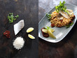 Sandacz na risotto w kompozycji z poszczególnymi składnikami do przygotowania potrawy. Sandacz, ryż, suszone pomidory, cytryna, zioła