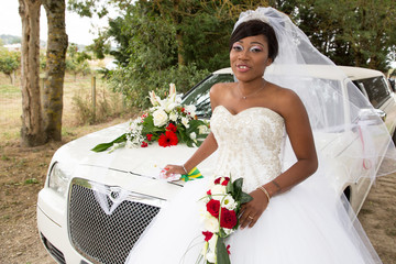 Wall Mural - pretty young african american black bride posing with white limousine car in wedding day